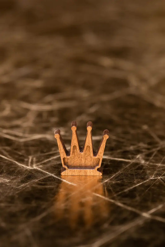 Symbolic fine art photograph of a wooden chess queen isolated against a dark background by Monika Burszczan