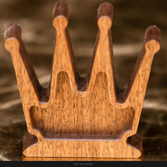 Close-up detail of a handcrafted wooden chess queen on a dark reflective surface, fine art photography by Monika Burszczan