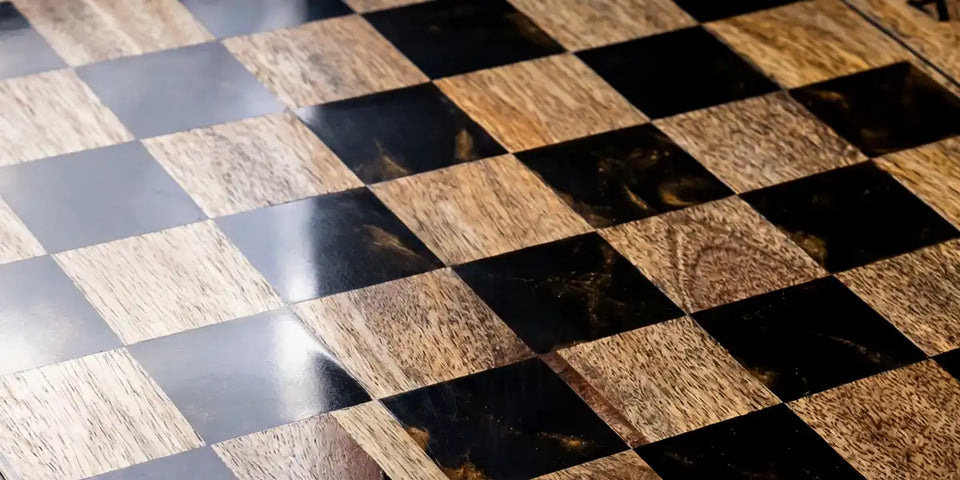A luxury desktop chess setup with a handcrafted solid wood board, vintage mechanical clock, and abstract chess-themed wall art in a sophisticated interior.