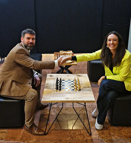 Chess journalist and WIM Fiona Steil-Antoni shaking hands with Michał Fudalej at a ChessboArt coffee chess table during the Global Chess Festival 2025 in the Hungarian National Gallery