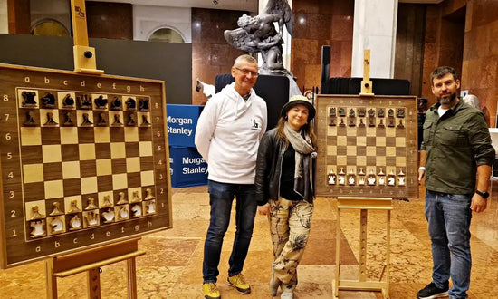 The greatest female chess player of all time, Judit Polgár, with the ChessboArt creator and a Morgan Stanley representative, showcasing two luxury vertical wall-mounted chess sets in Hungary.