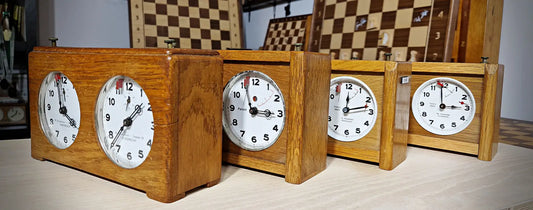 Evolution of Koopman chess clocks: Vintage collection ranging from 1940s oak models to 1980s designs.
