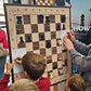 Children solving a chess puzzle on the ChessClub wall chess board at a tournament