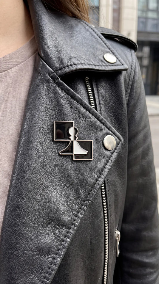 ChessboArt pin fastened to a black biker jacket lapel, urban street style shot