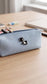 Chess lifestyle enamel pin attached to a blue canvas pencil case on a wooden desk