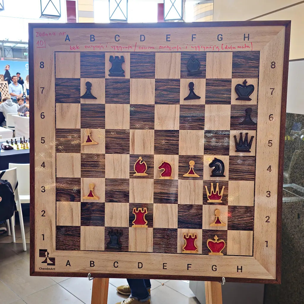 Wall chess board with red and dark pieces set up as a chess puzzle, task written above in marker