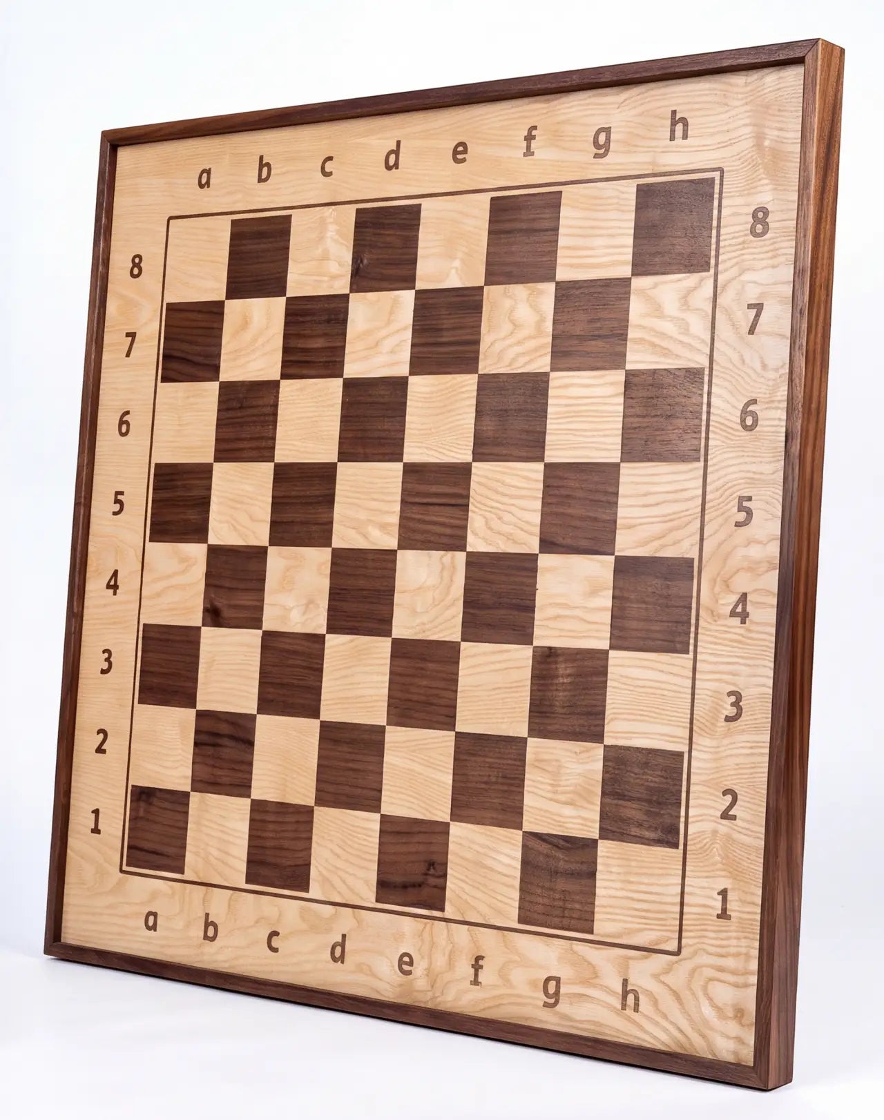 Angled view of the ChessboArt 800 wall-mounted chessboard, primarily made of light ash wood with dark contrasting walnut squares, showcasing the natural wood grain.