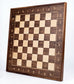 Angled view of the ChessboArt 800 wall-mounted chessboard made from American walnut and light ash, showcasing the solid wooden frame and edge details.