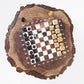 An angled, low-perspective photograph showcasing the incredible depth and wood grain texture of the ChessboArt walnut stump chess table with its embedded epoxy board and pieces.