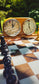 Close-up of the glossy epoxy resin playing surface and chess clock on the ChessboArt walnut table.