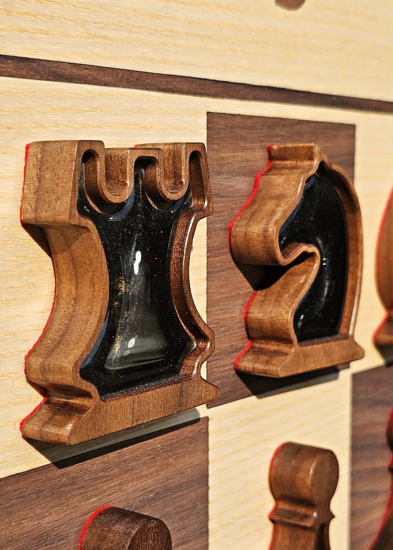 Close-up of rook and knight chess pieces with pearl black magnetic epoxy resin inlays