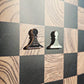 Black and cream enamel pawn chess pieces shaped like pin badges on the Ivory Grain magnetic board