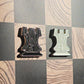 Black and cream enamel rook chess pieces shaped like pin badges on the Ivory Grain magnetic board