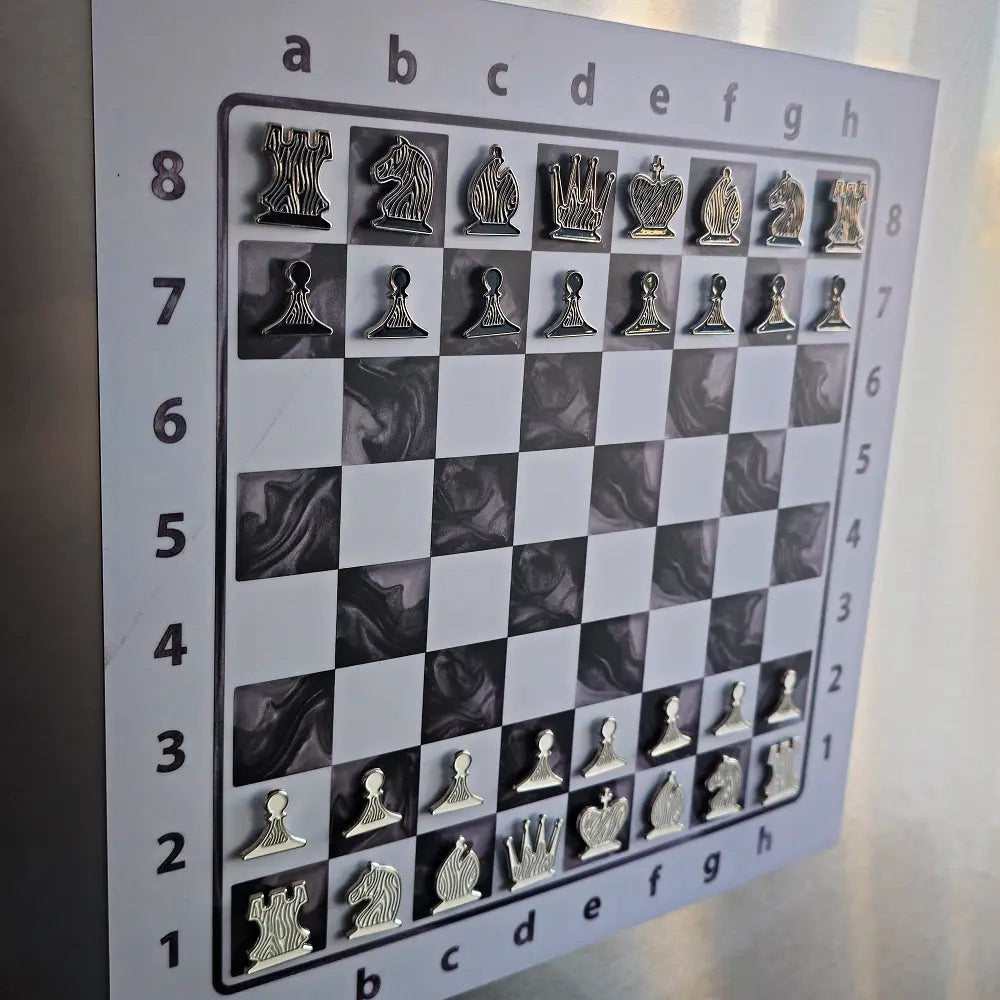 Close-up of the Epoxy Ivory magnetic chessboard on a fridge, enamel pin chess pieces in starting position