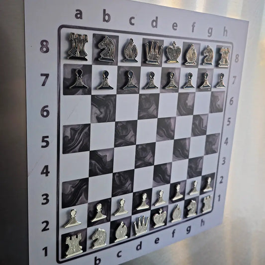 Close-up of the Epoxy Ivory magnetic chessboard on a fridge, enamel pin chess pieces in starting position