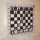 Wide view of a hanging magnetic chess set with Ivory Grain board mounted on a wall