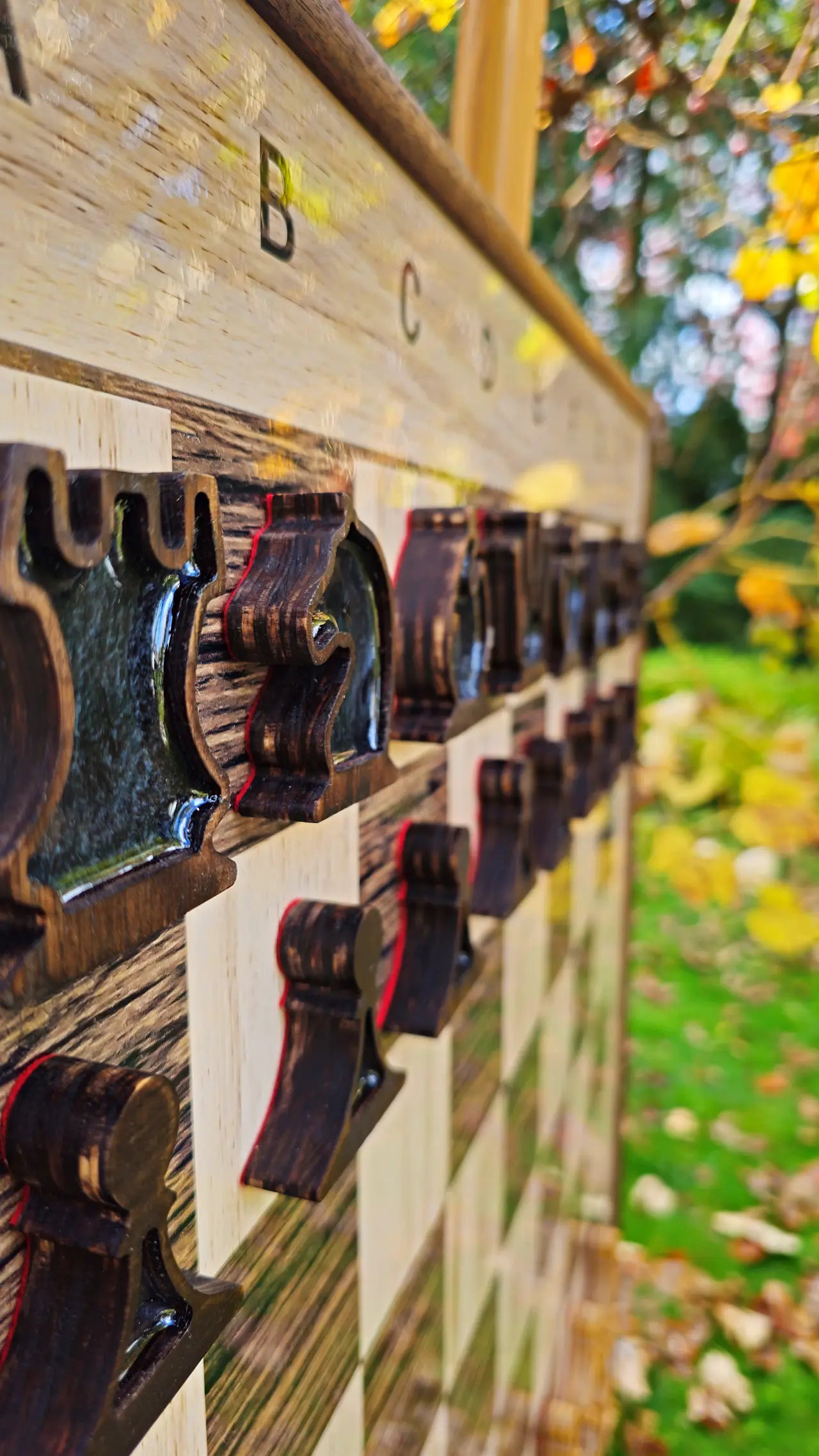 Dark plywood magnetic chess pieces on a wall chess board, close-up in autumn light