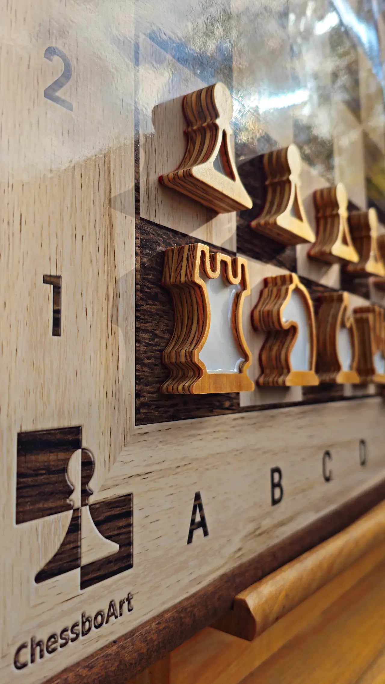 Plywood chess pieces with white epoxy resin fills on the first rank of the ChessClub board