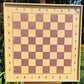 Front view of the empty ChessboINK wall-mounted chessboard made of ash wood, highlighting the pink painted squares, coordinate notation, and natural wood grain.