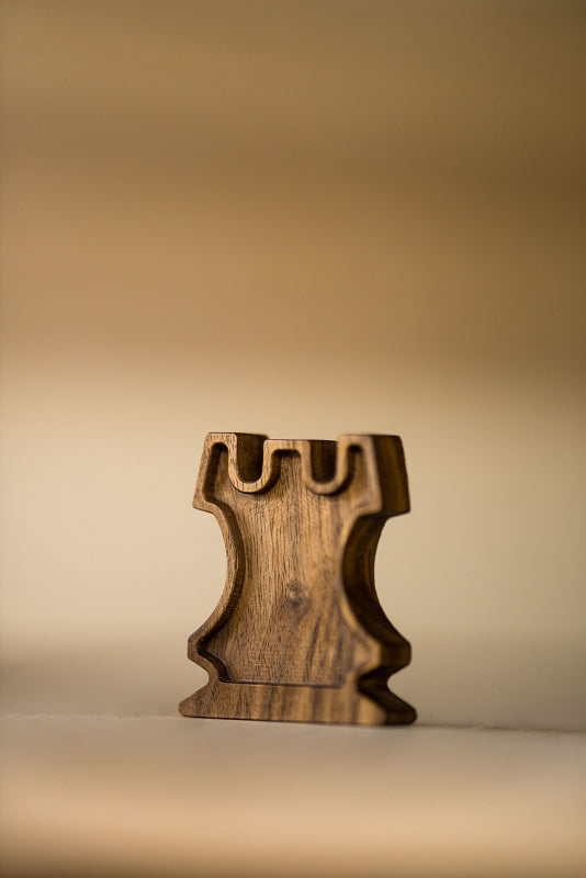 Fine art photograph of a handcrafted wooden chess rook emphasizing structure and geometry