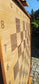 Low angle close-up of the ChessboArt 800 empty wooden chessboard. This dynamic perspective emphasizes the smooth, flat surface where the heartwood ash and American walnut playing squares blend seamlessly into the numbered outer margins.