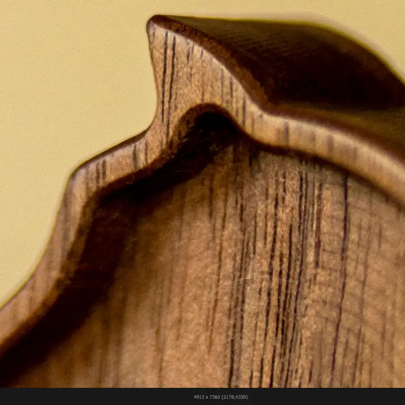 Close-up detail of a handcrafted wooden chess knight showing sculptural form and wood grain