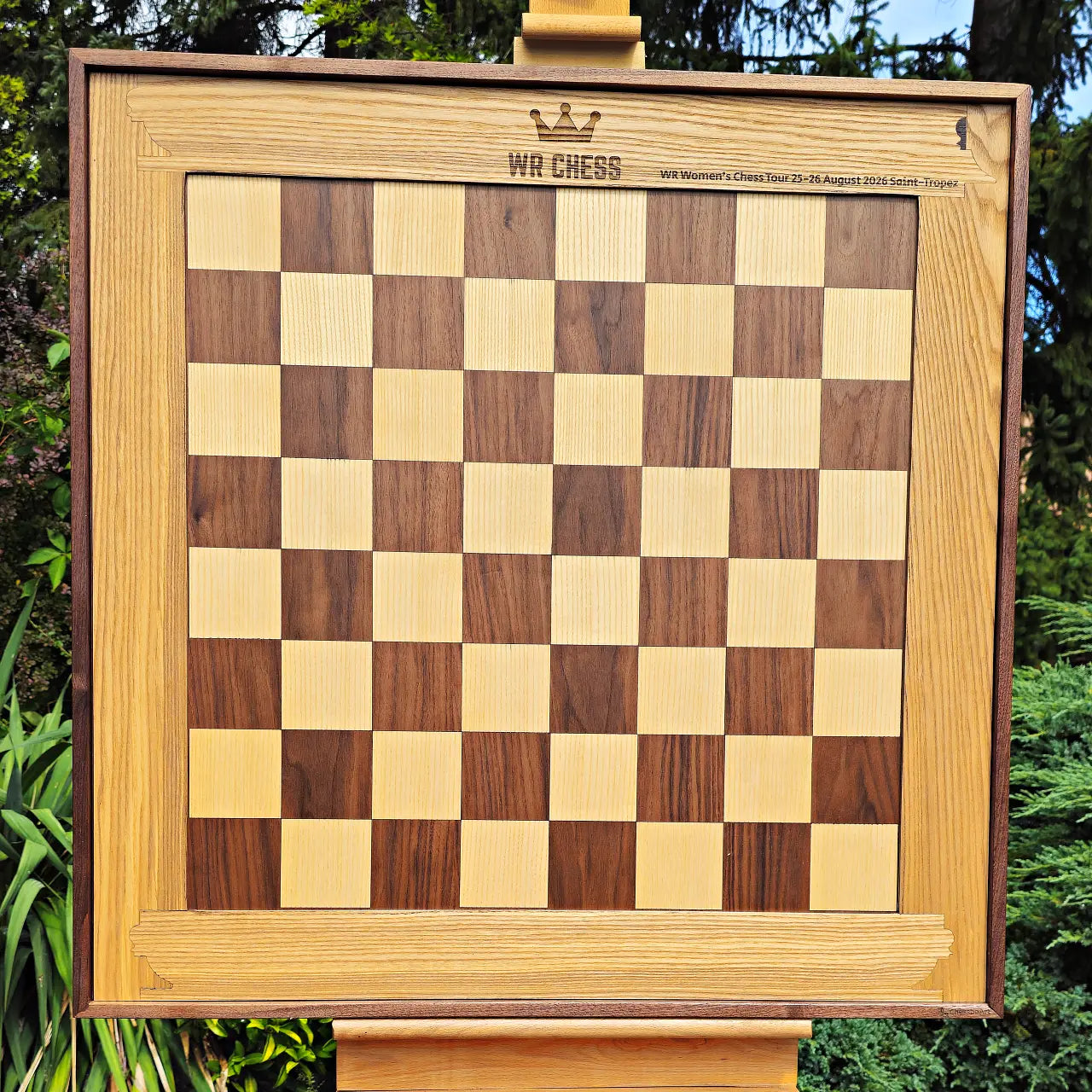 The same wall chess board shown with the personalized ash heartwood frame installed, WR Chess side facing out