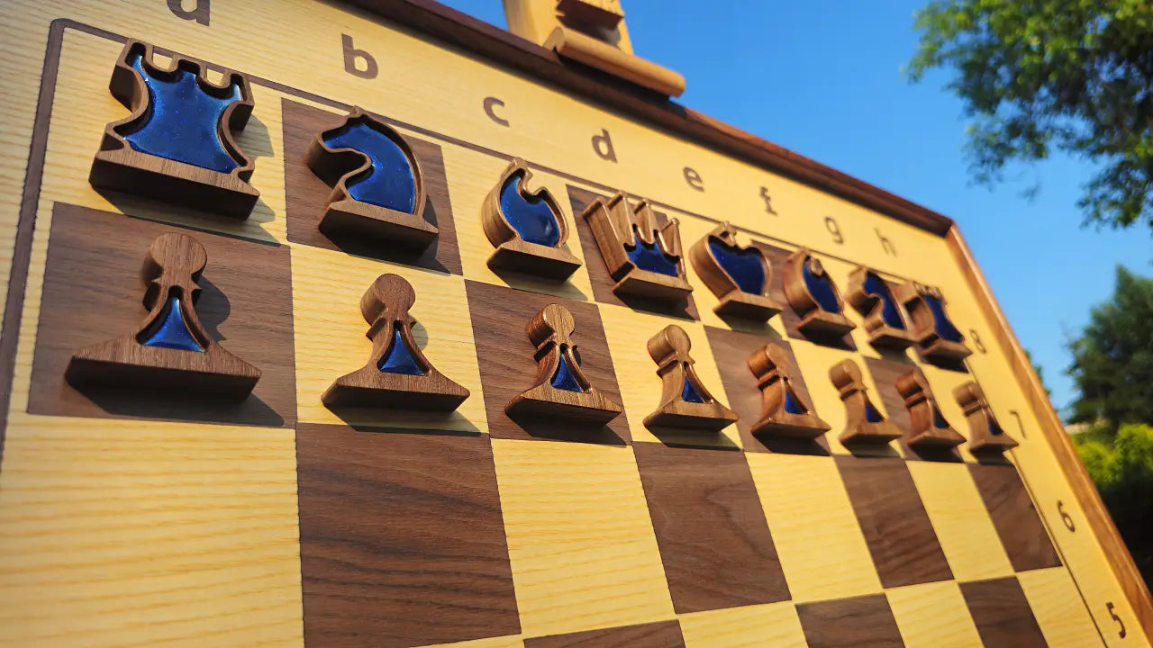 Side-angle shot of a vertical chess set with blue epoxy resin magnetic piece inlays in sunlight