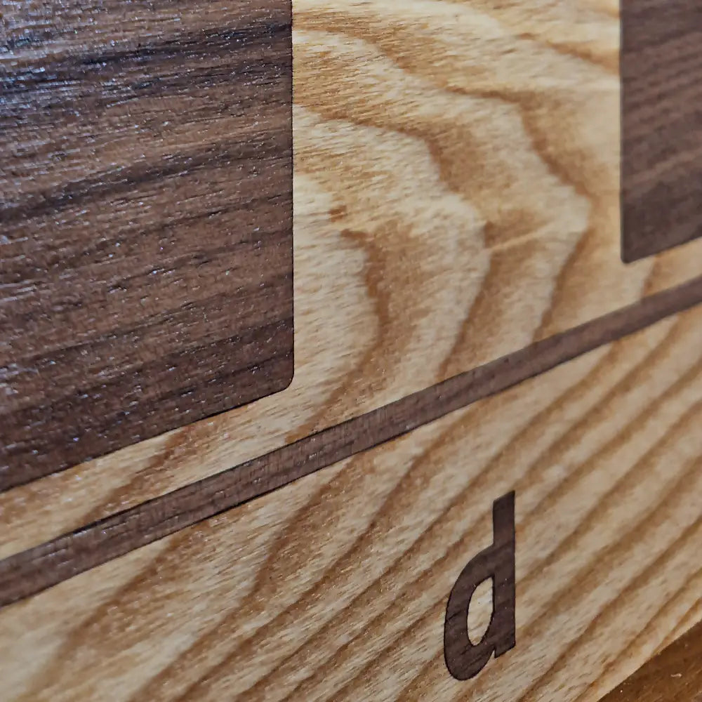 Detail of ChessboArt800 wall chess board edge in dark ash wood, showcasing precision craftsmanship and premium materials